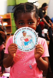 child holding a world read aloud day card