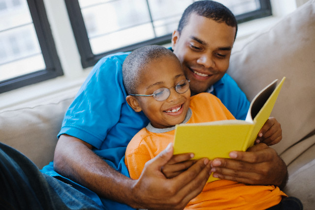 Father and son reading a book together