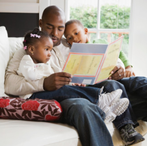 Dad reading a book to his two young kids